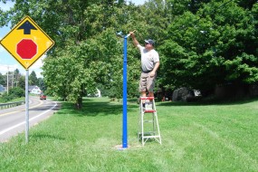July 2015 photo of Mike Wintermantel painting the newly installed post for the marker